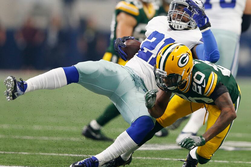 Dallas Cowboys running back Ezekiel Elliott (21) is tackled by Green Bay Packers cornerback...