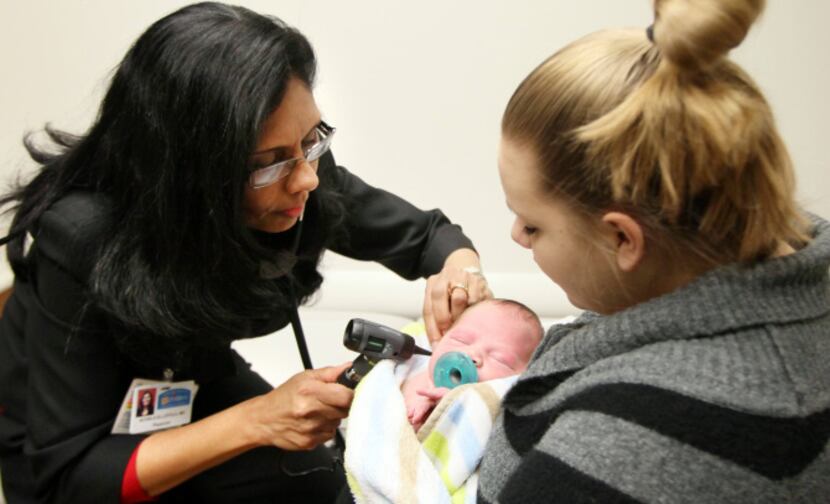 Dr. Achala Ellepola examined newborn Dorrian Taylor as his mother, Ashley Cosper, held him...