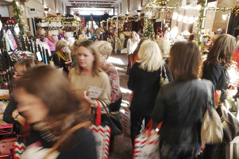 A slow shutter speeds capture the crowd at 'Neath the Wreath Holiday Gift Market at the...