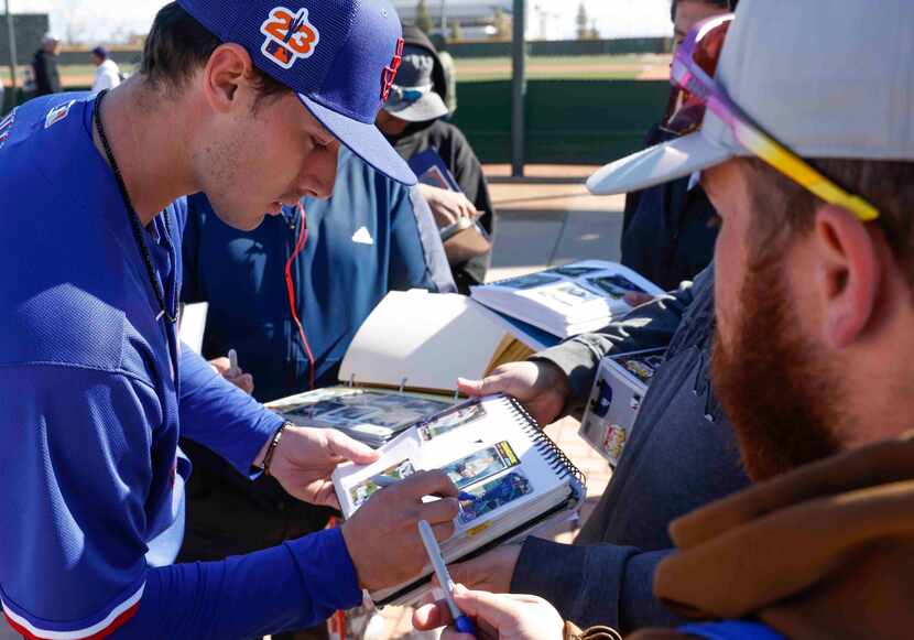 Texas Rangers right handed pitcher Cole Winn gives autographs to fans before the first...