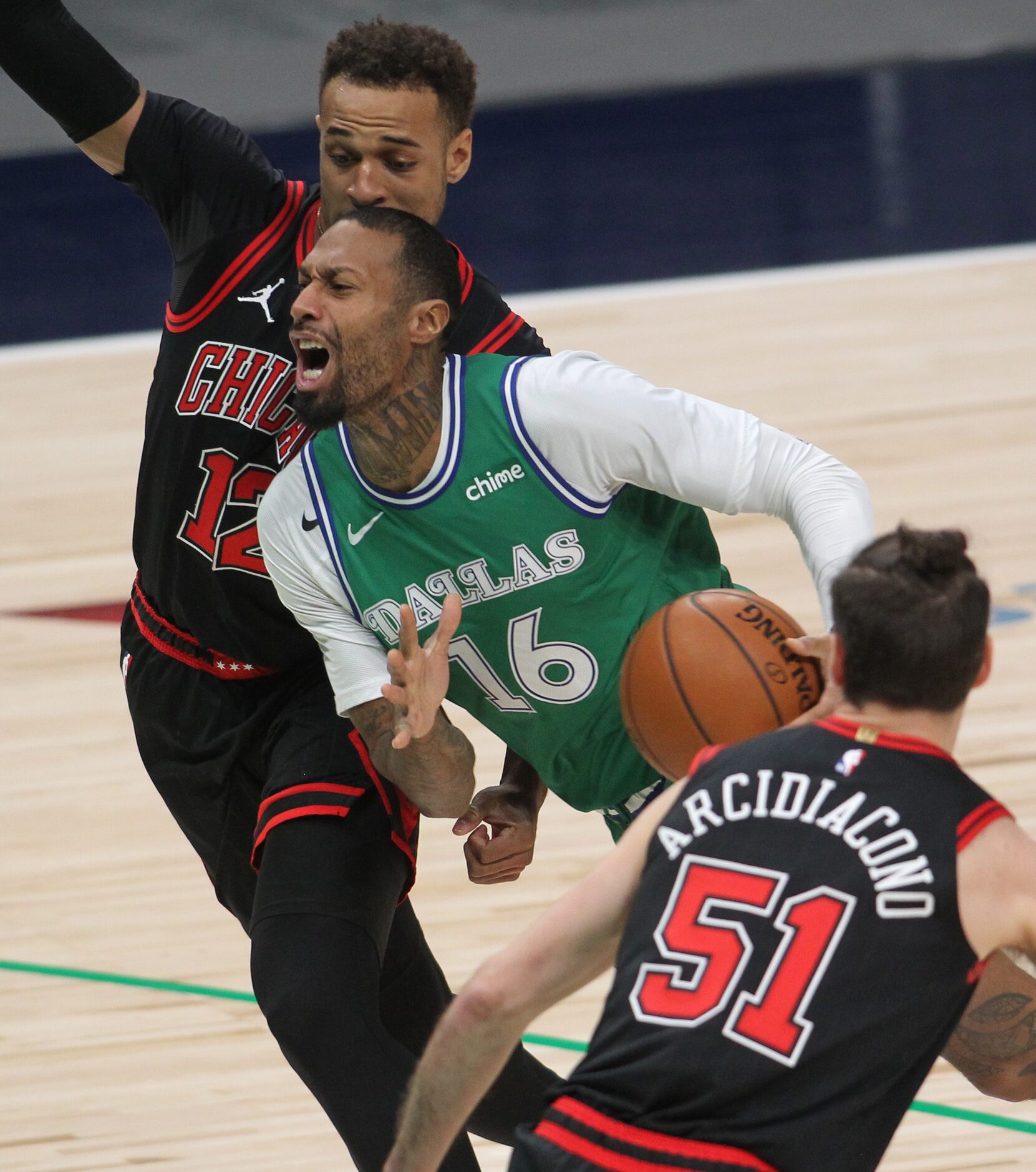 Dallas Mavericks forward James Johnson (16) drives to the basket between the defense of...