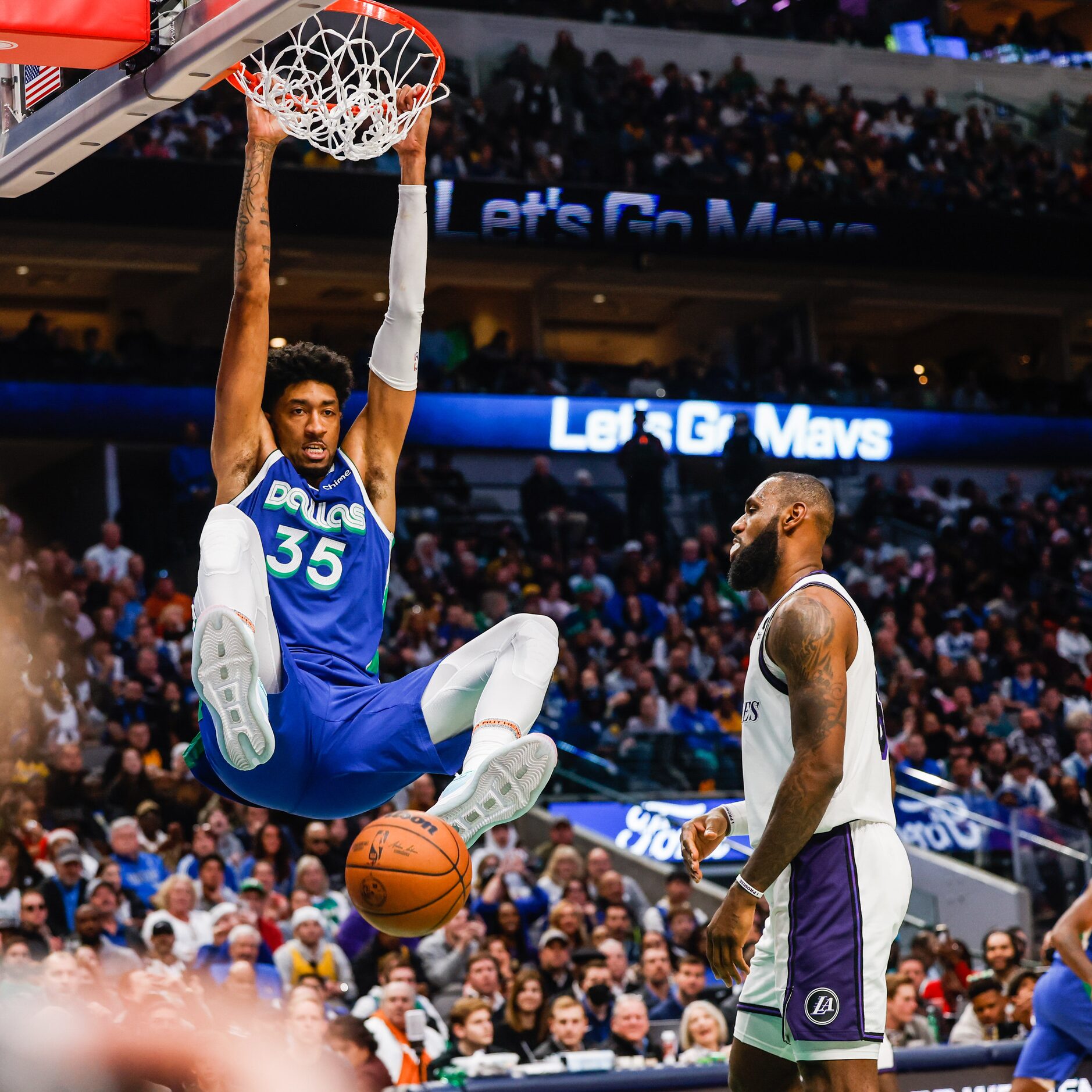 Dallas Mavericks forward Christian Wood (35) dunks the basketball next to Los Angeles Lakers...