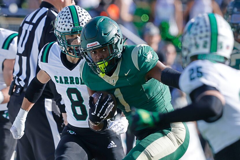 DeSoto's Deondrae Riden Jr. (1) carries the ball against Southlake Carroll's Carter High (8)...