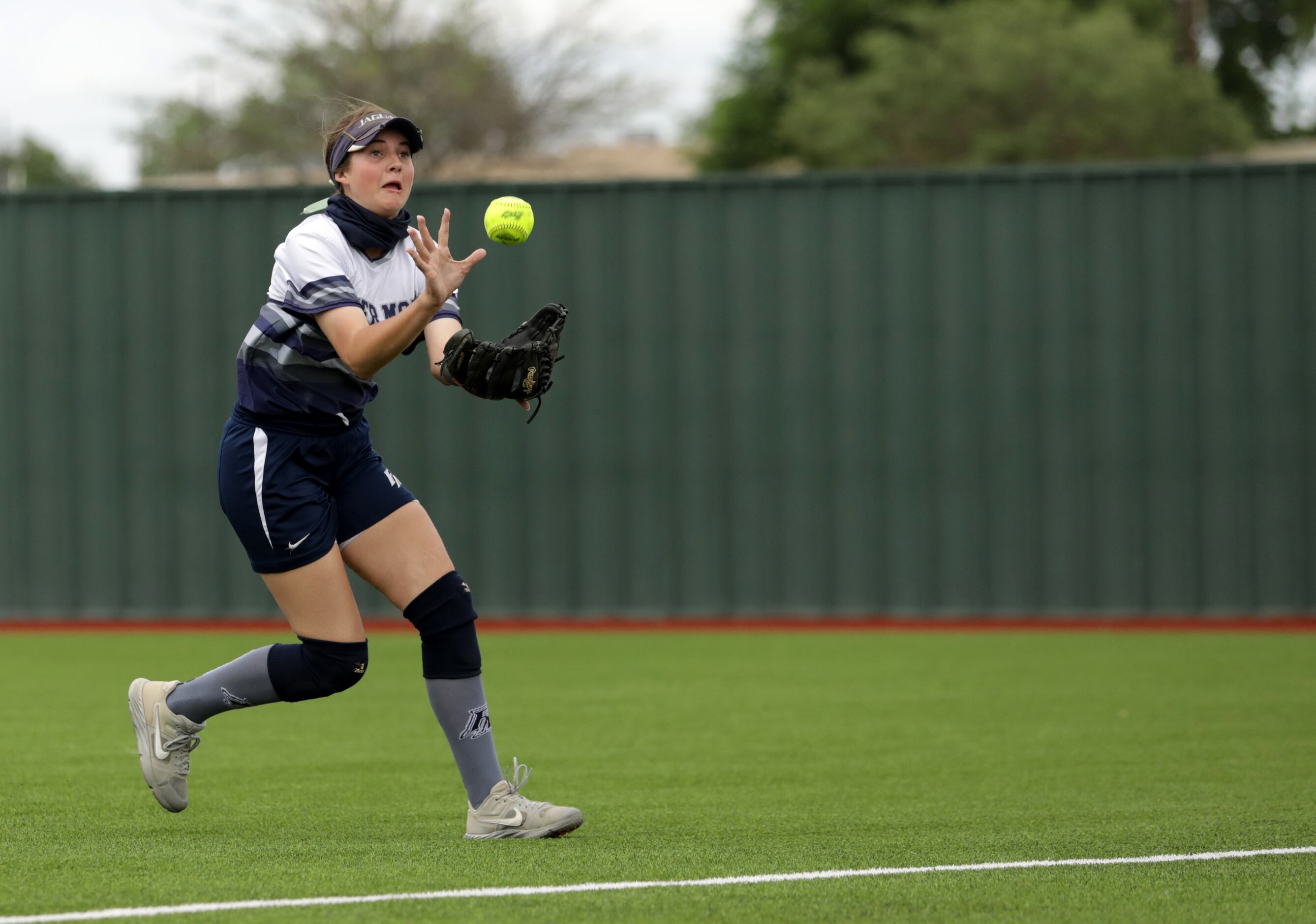 Flower Mound High School player #23, Courtney Cogbill, snags the ball during a softball game...