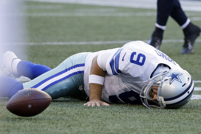 Dallas Cowboys quarterback Tony Romo lies on the turf after a play early in the first half...