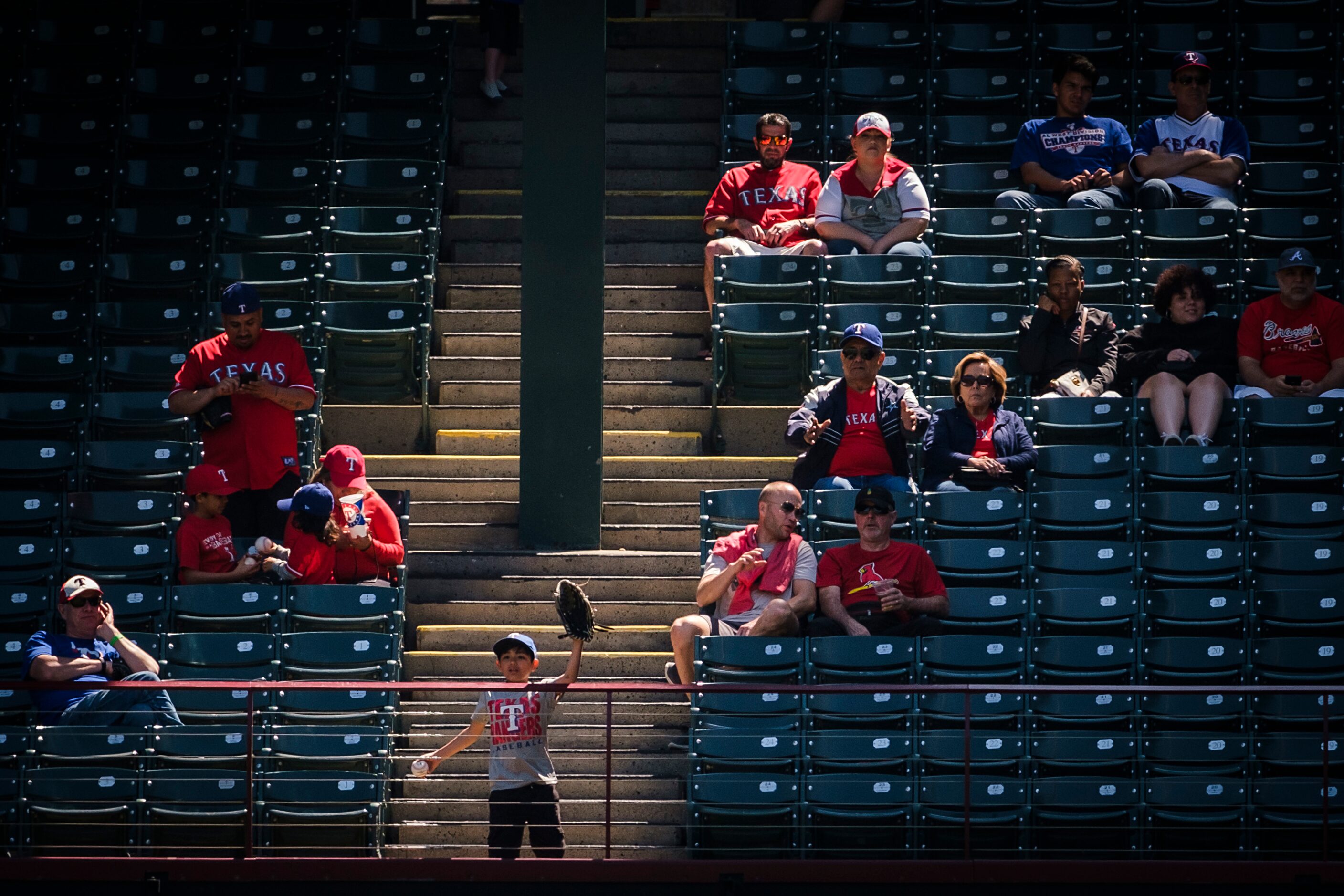 Fans try to get a ball thrown their way during the fourth inning of a spring training...