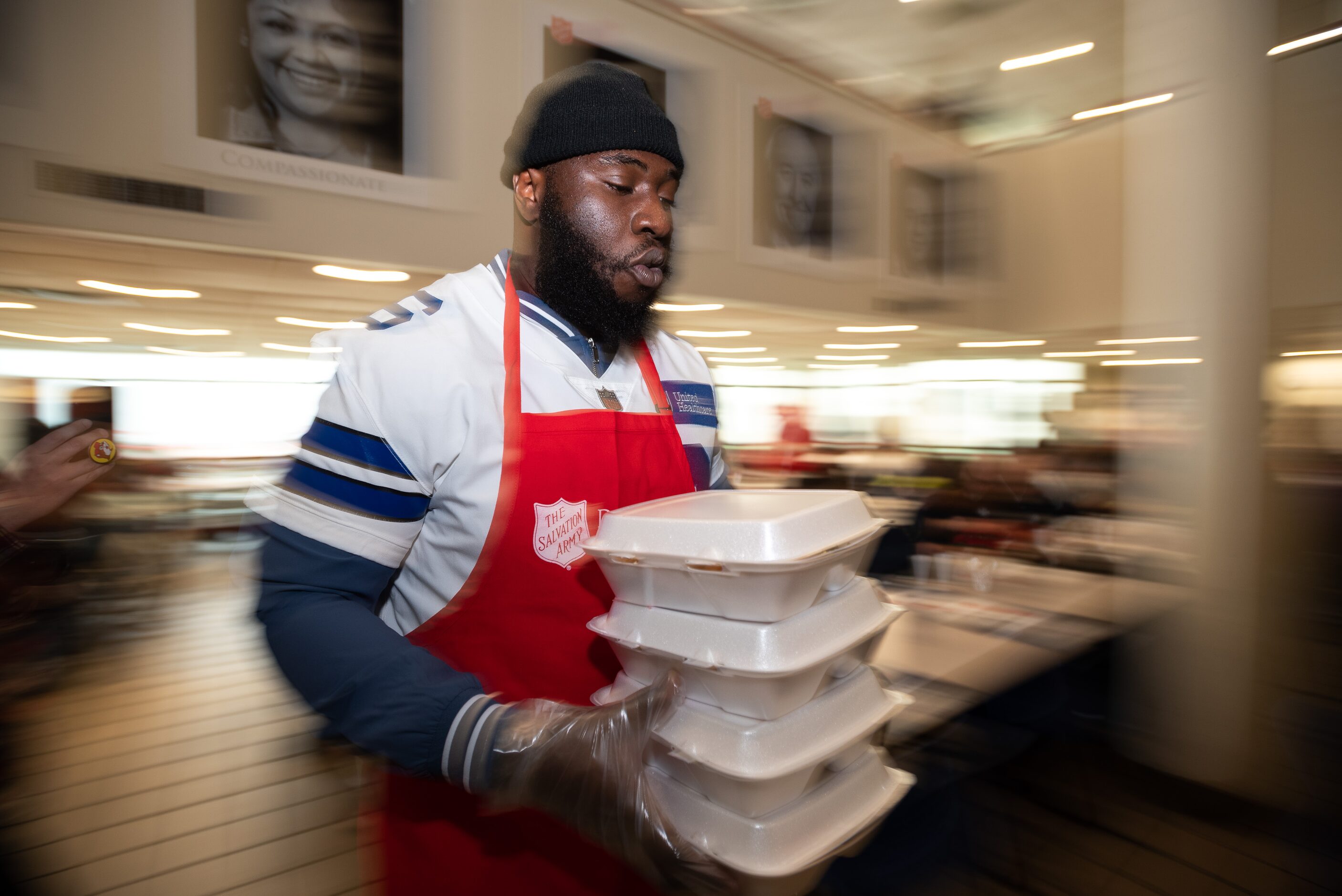 Dallas Cowboys defensive tackle Neville Gallimore carries containers of Thanksgiving meals...