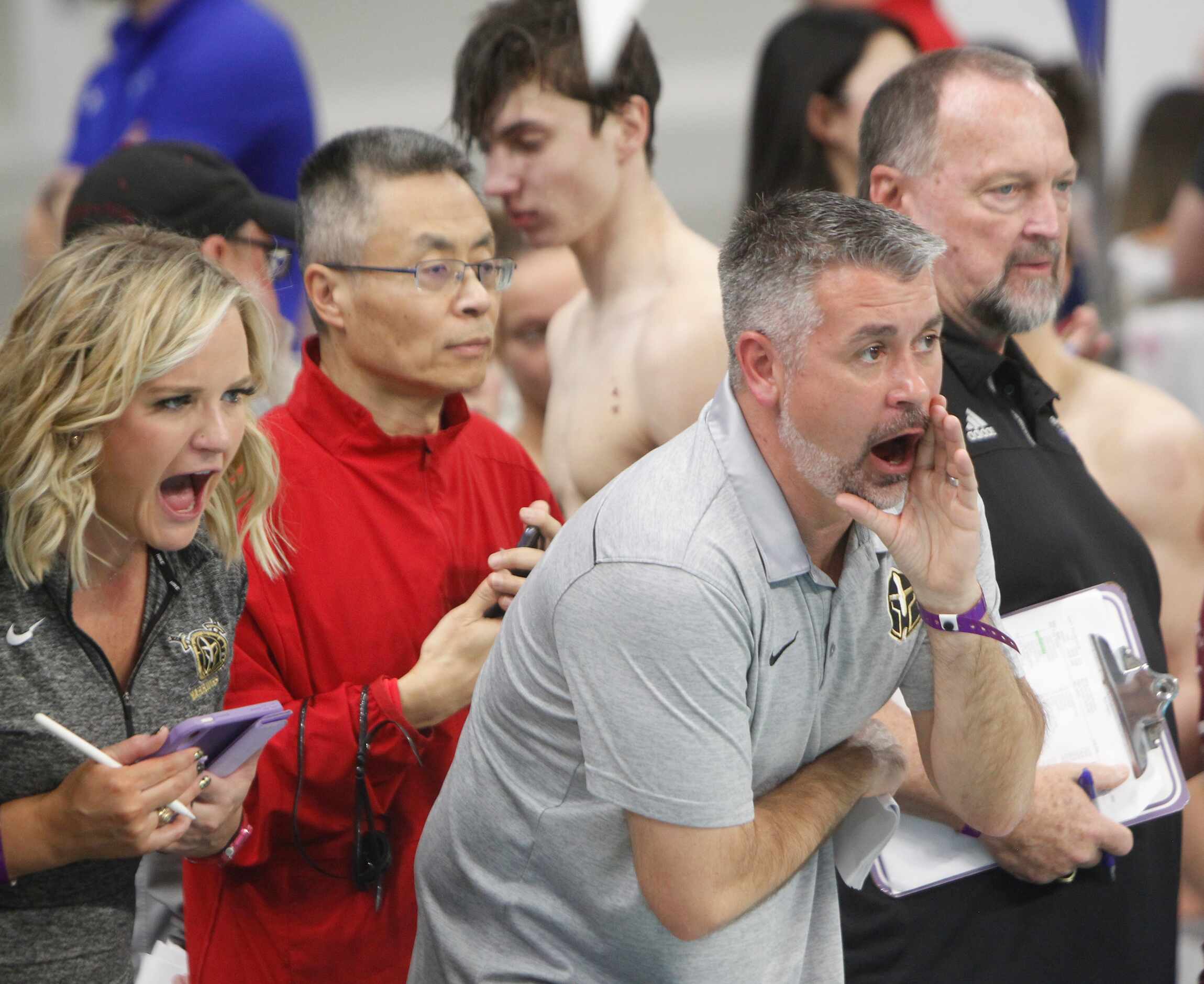 Coaches and supporters at poolside voice their support during a 5A race. The first day of...