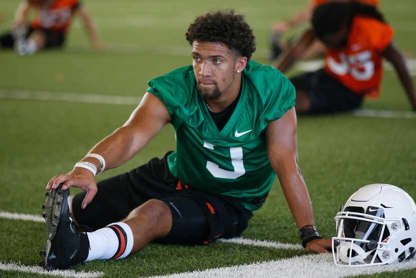 Oklahoma State quarterback Spencer Sanders stretches during an NCAA college football...