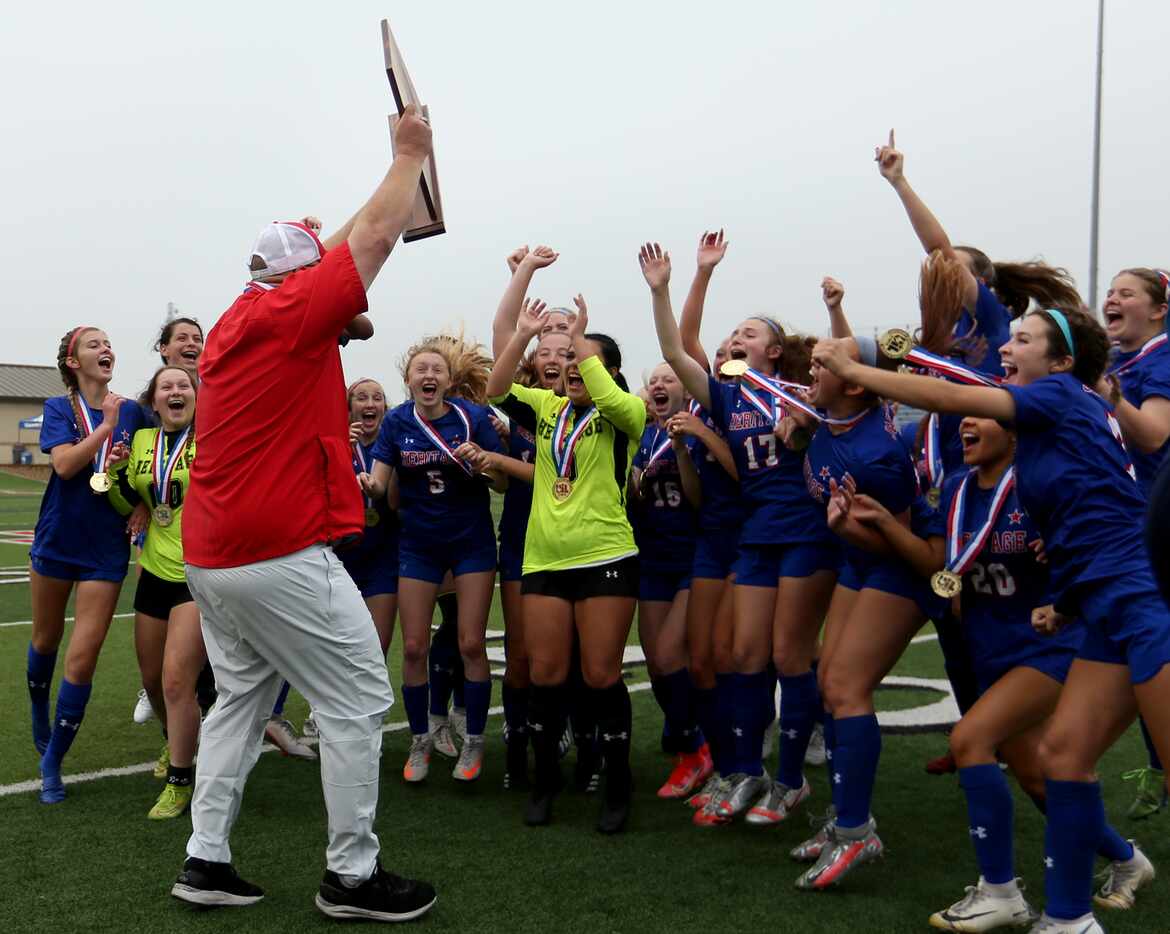Midlothian Heritage head coach Gerald Slovacek cheers with his players as he holds up the...