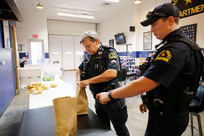 Dallas police senior corporal Kevin James, left, and officer Adrian Alcorta pick up BBQ...