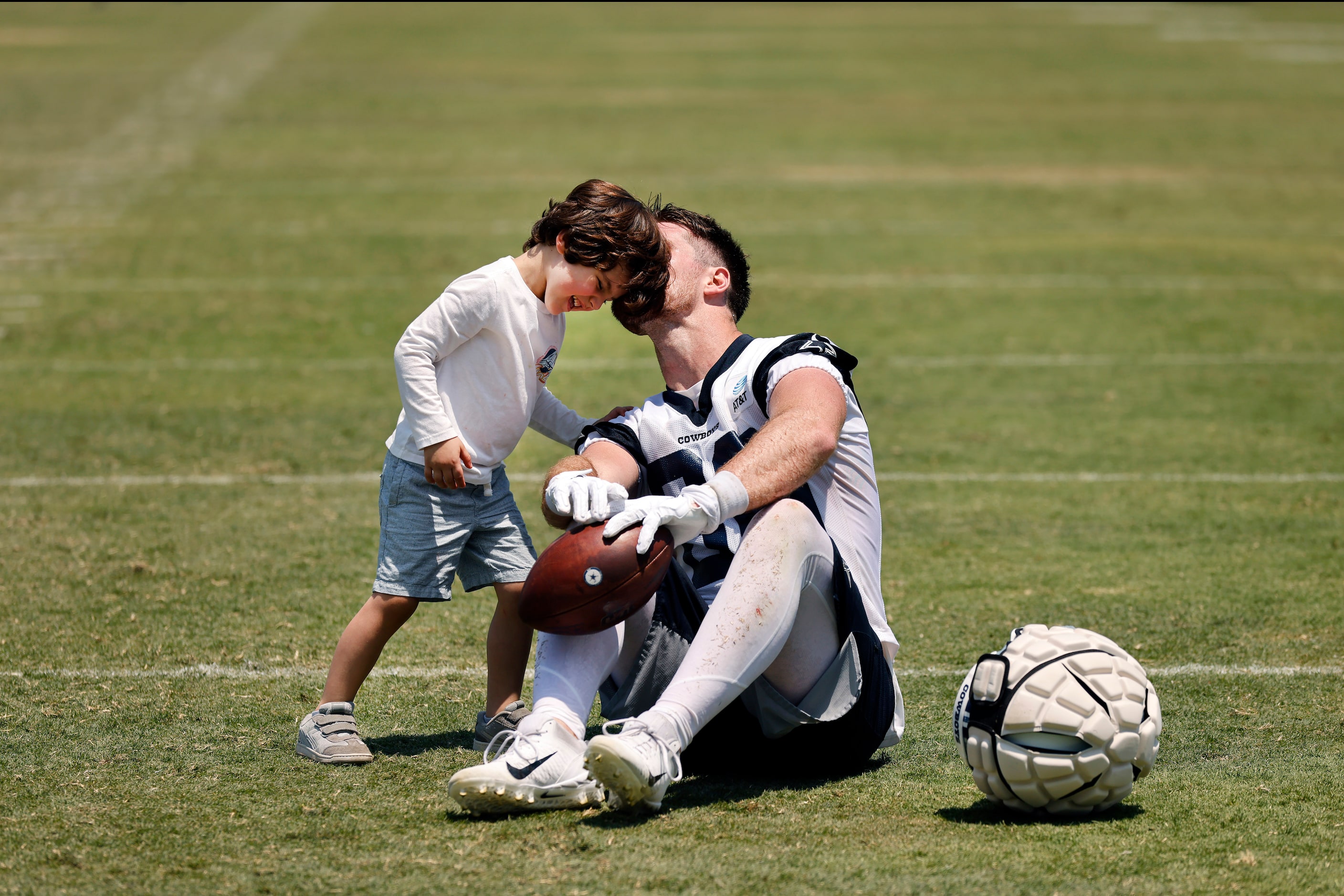 Dallas Cowboys tight end Dalton Schultz (86) gives his son Theodore Schultz a kiss on his...