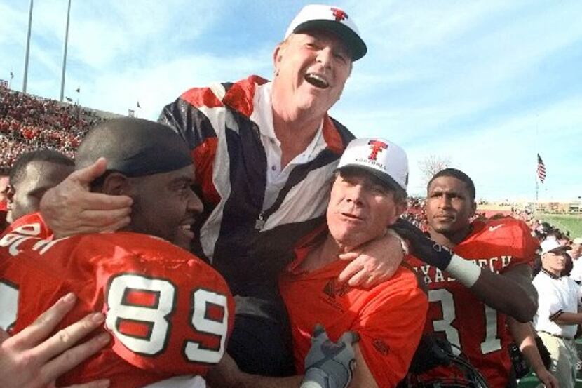 ORG XMIT: S129536E0_WIRE Texas Tech head coach Spike Dykes is lifted by Texas Tech alum and...