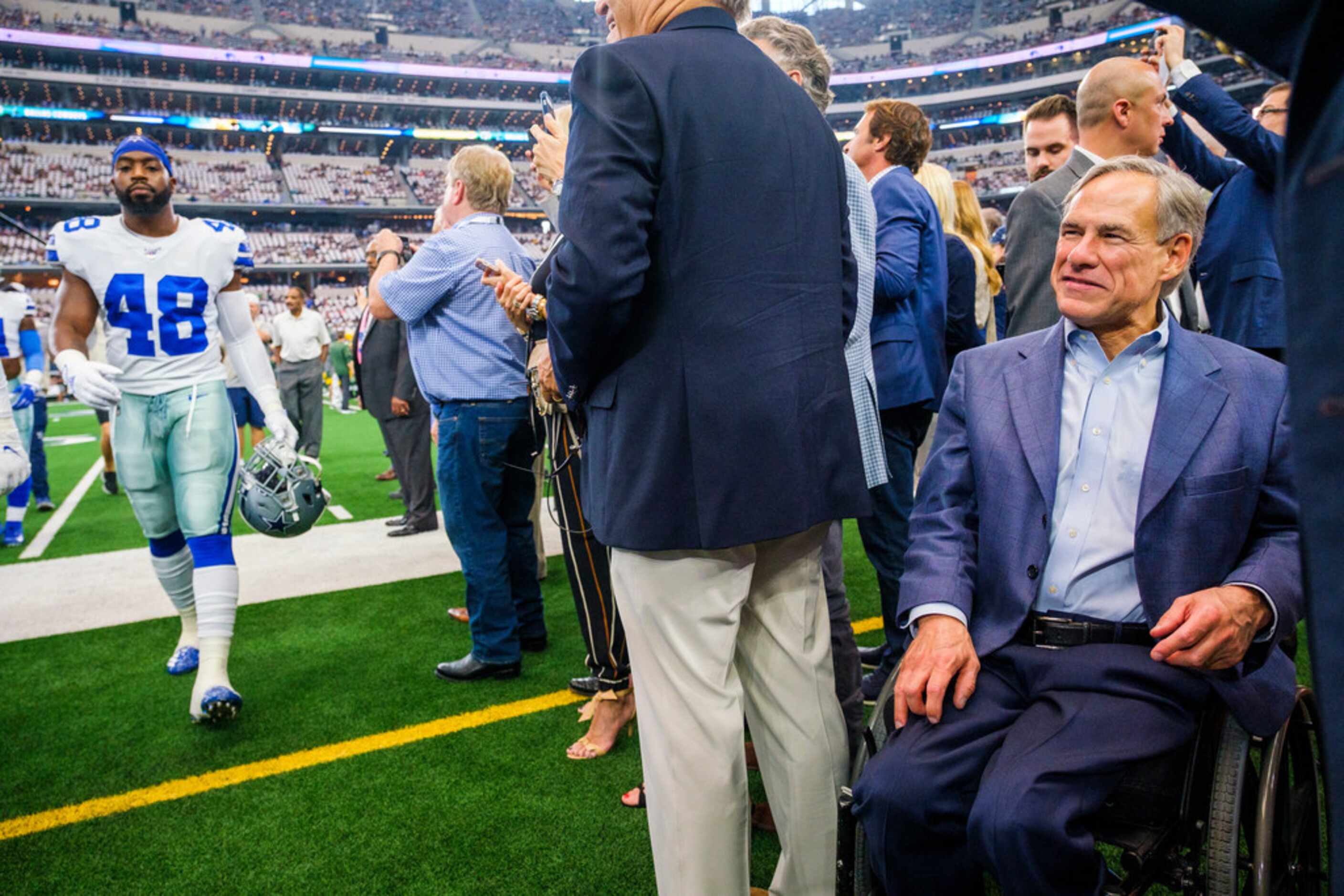 Texas Gov. Greg Abbott watches the teams warm up before an NFL football game between the...