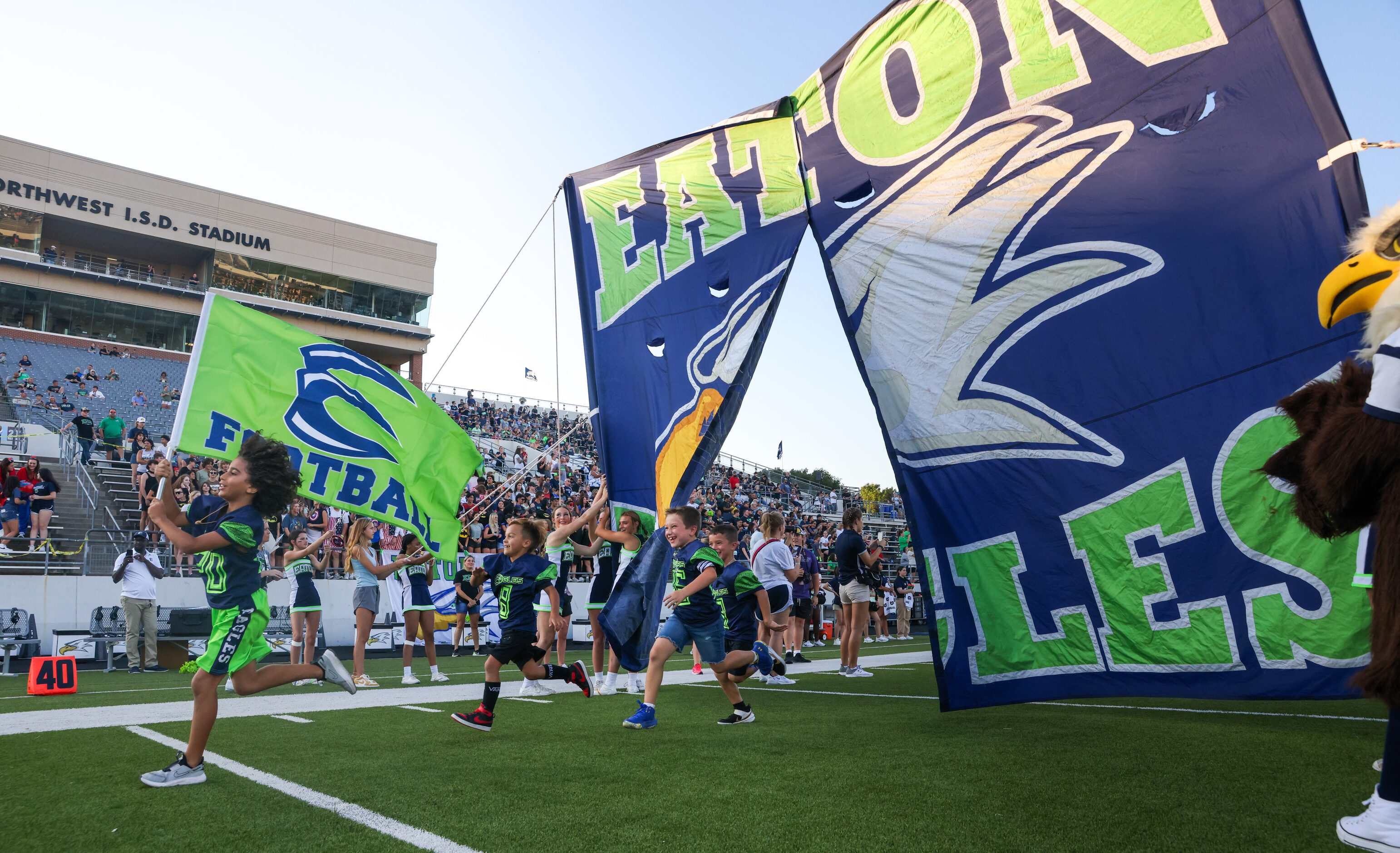 Young V.R. Eaton High School fans run across the field before the Eaton Eagles enter the...