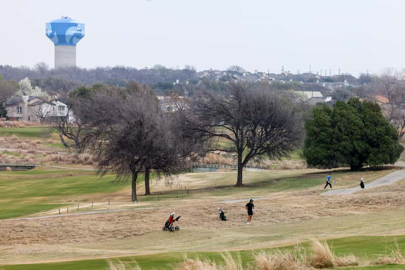 A water tower rises over the landscape as people play golf at Maridoe Golf Club. The course...