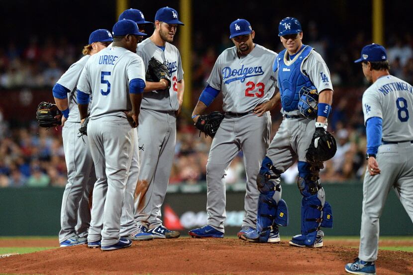 Los Angeles Dodgers's manager Don Mattingly (R) approaches pitcher Clayton Kershaw (C) to...