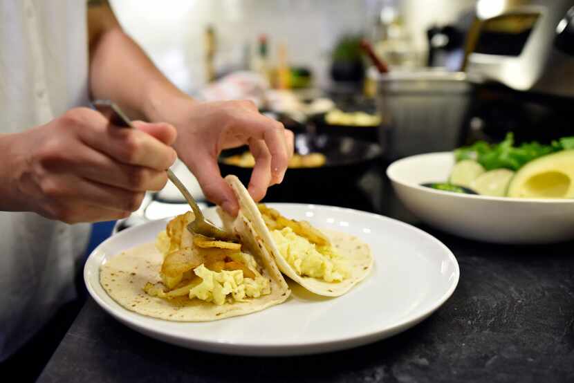 Chef Angela Hernandez, 34, places scrambled egg and potato onto tortillas.