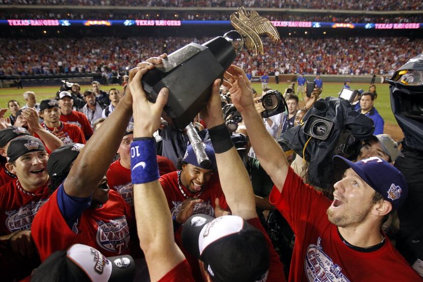 Texas Rangers Cliff Lee and teammates hoist the American League trophy and celebrate after...