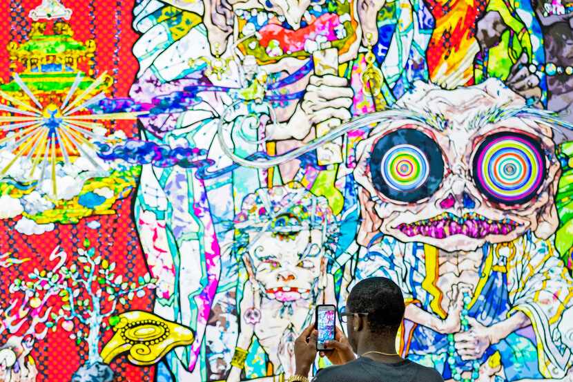 Dominique Carter takes photos with his cellphone for social media at Takashi Murakami's...
