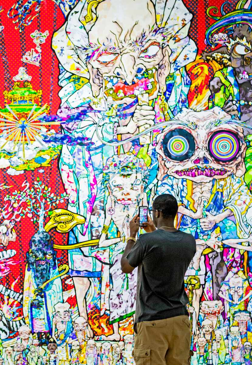 Dominique Carter takes photos with his cellphone for social media at Takashi Murakami's...