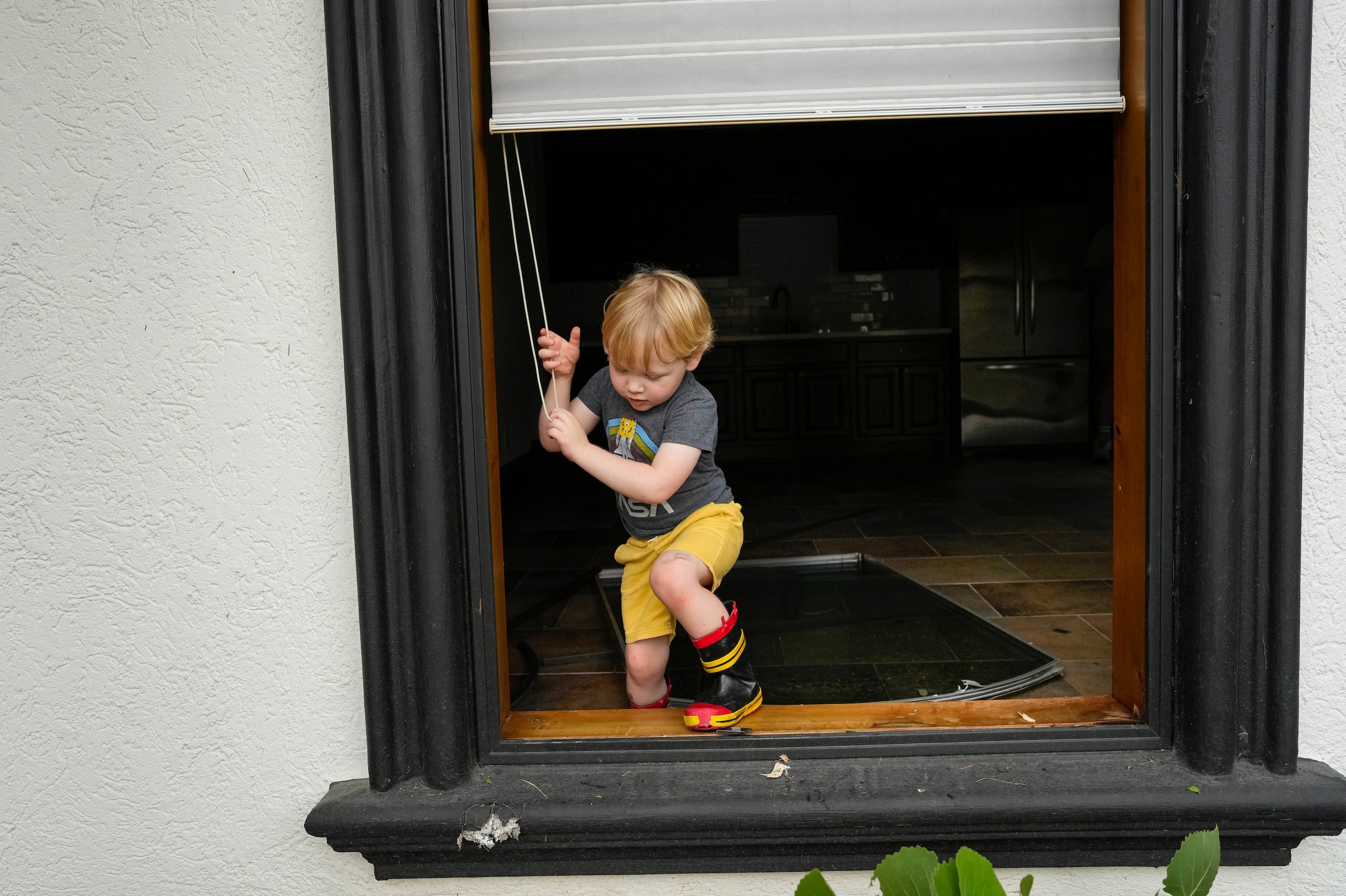 Patrick Haggard gets out of his house through an open window, which the glass was blown in...