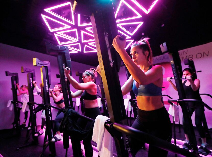 Jennifer Cantelmo, right, works out on the Versa Climber machine at District Climb in Dallas.