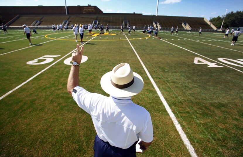 Highland Park head football coach Randy Allen calls a play from the sideline as his team...