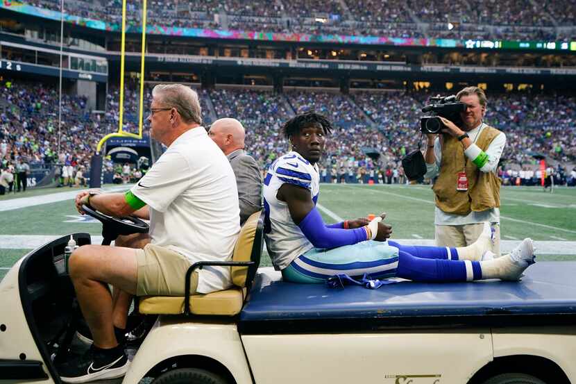 Dallas Cowboys linebacker DeMarvion Overshown is taken off the field on a cart during a...