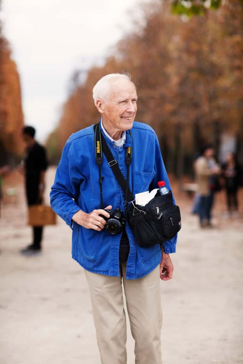 Bill Cunningham with his familiar Nikon camera gear and signature blue French worker's jacket.