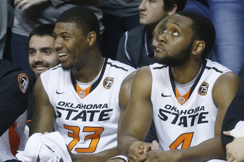 Oklahoma State guard Marcus Smart (33) smiles as he sits on the bench with Brian Williams...