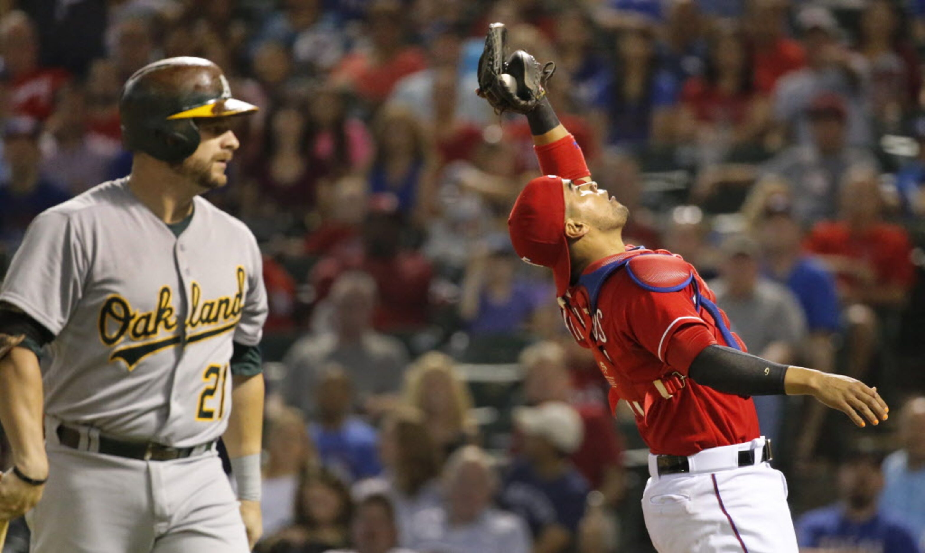 Texas catcher Robinson Chirinos catches a foul pop to retire Oakland's Stephen Vogt in the...