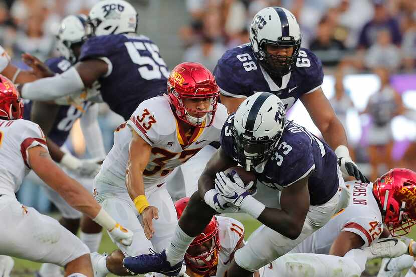 TCU running back Sewo Olonilua (33) breaks through the middle for a short gain in the first...