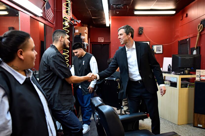 Democratic Senate candidate Beto O'Rourke shakes the hand of barber Ivan Dominguez, 26, of...