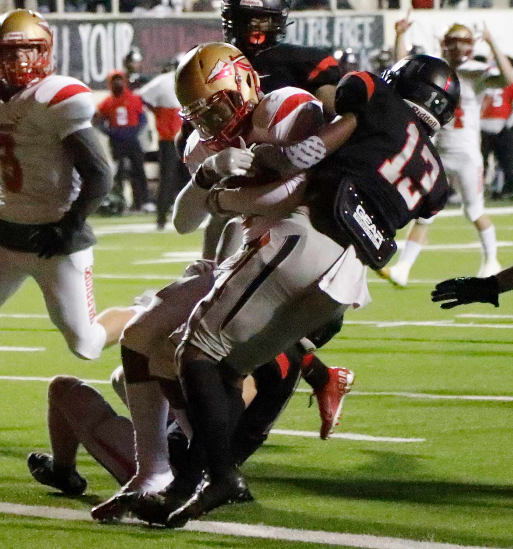 South Grand Prairie High School running back A.J. Newberry (30) breaks through the tackle...