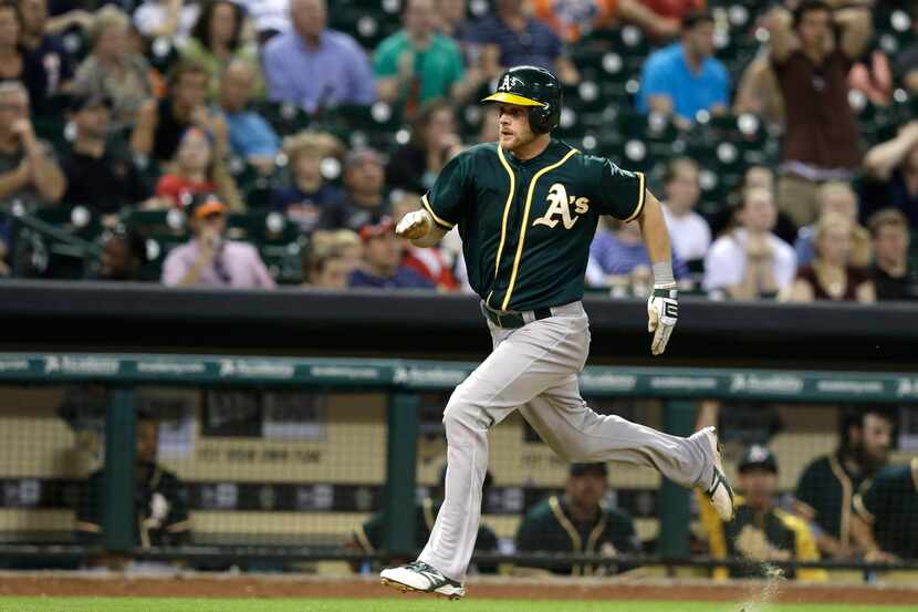 Oakland Athletics' Craig Gentry races down the third base line to score on a Daric Barton...