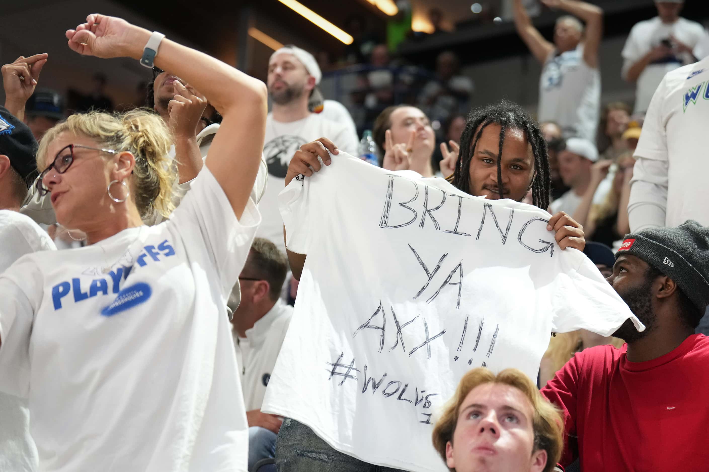 A Minnesota Timberwolves fan holds a t-shirt reading “Bring Ya Axx!!!!” a play on Minnesota...