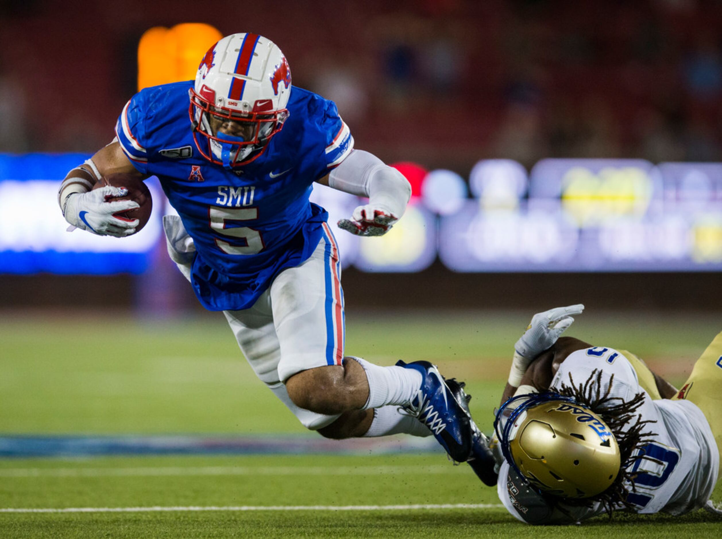 SMU Mustangs running back Xavier Jones (5) is tackled by Tulsa Golden Hurricane safety Manny...