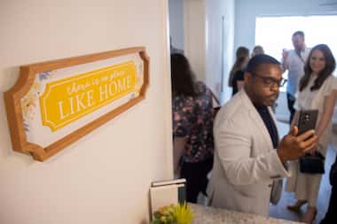 Dallas City Council Member Zarin Gracey takes photos of a two-bedroom unit while touring it...