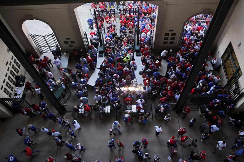 Fans stream in to the home plate entrance before the Texas Rangers opening day game against...