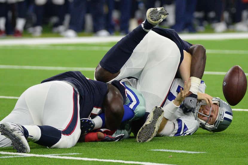 Dallas Cowboys quarterback Cooper Rush (7) fumbles the ball as he is hit by Houston Texans...