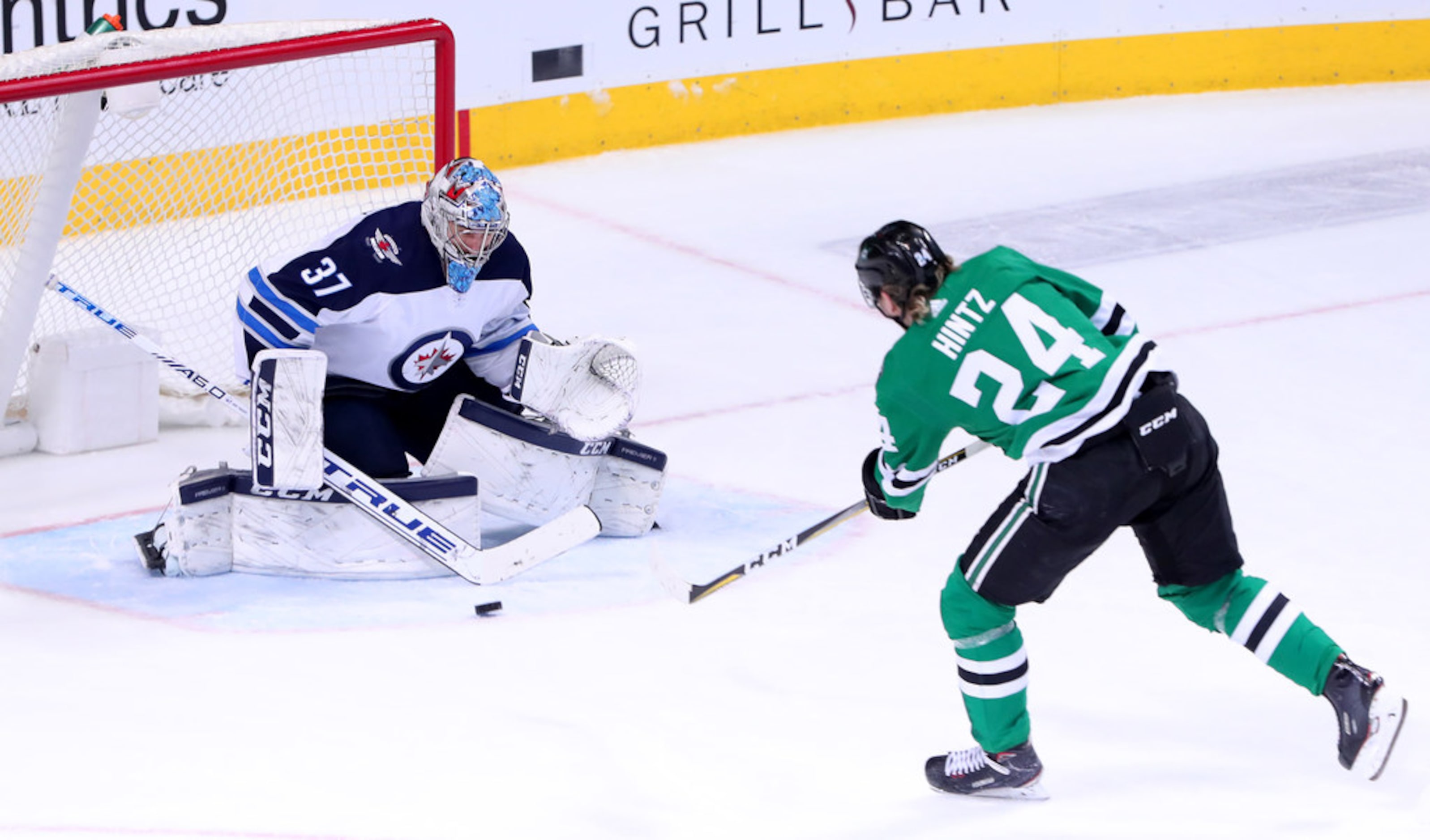 DALLAS, TEXAS - JANUARY 19: Connor Hellebuyck #37 of the Winnipeg Jets blocks a shot on goal...