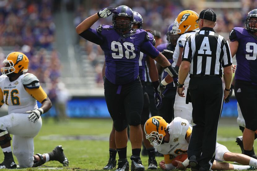 Jon Lewis #98 of the TCU Horned Frogs celebrates a sack against Bryan Bennett #3 of the...