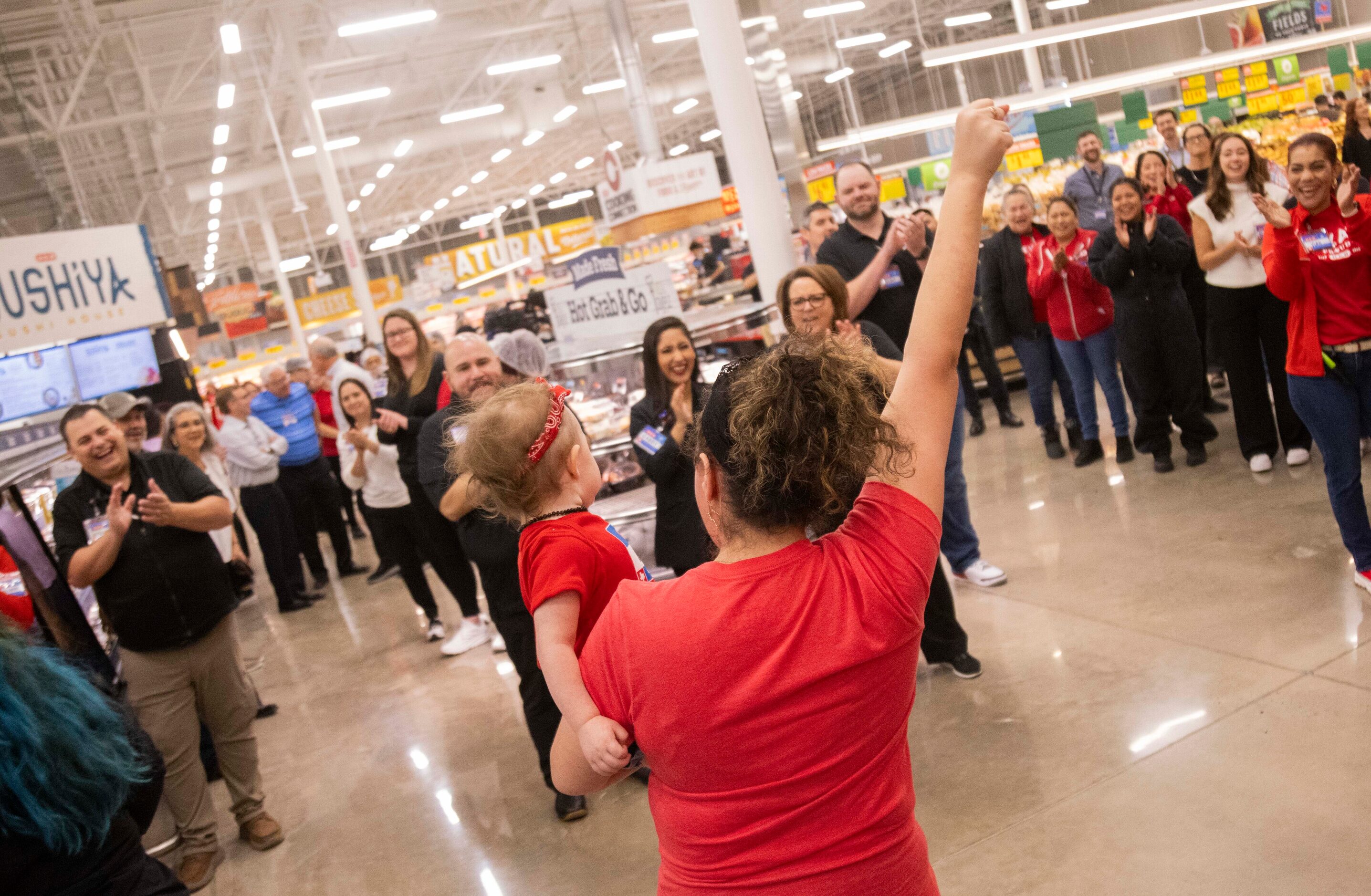 Ellie Woslager of Allen celebrates the grand opening of the H-E-B store in Allen while...