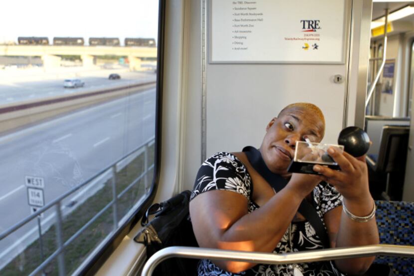 Alafia Moore put on makeup while riding the DART train from Las Colinas Urban Center to...