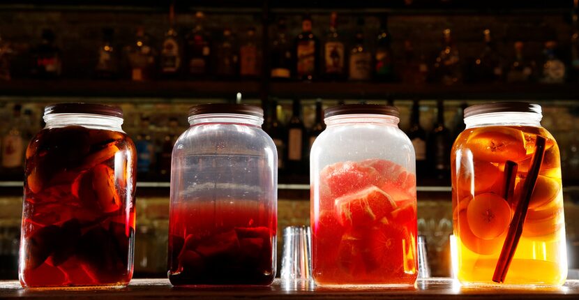 Infused alcohols (from left): charred orange bourbon, blood orange and beet tequila,...