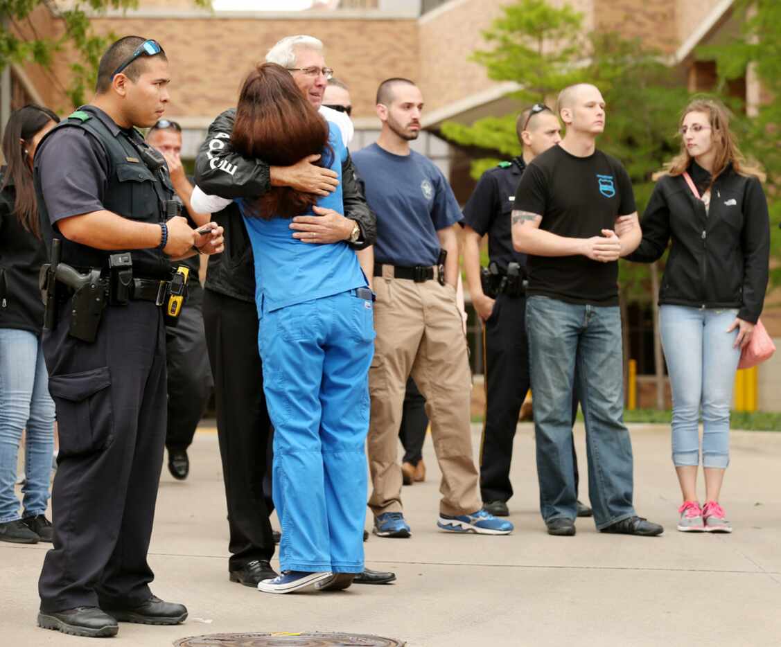 Steve Ledbetter, a retired Dallas police officer of 40 years, embraced a mourner outside...
