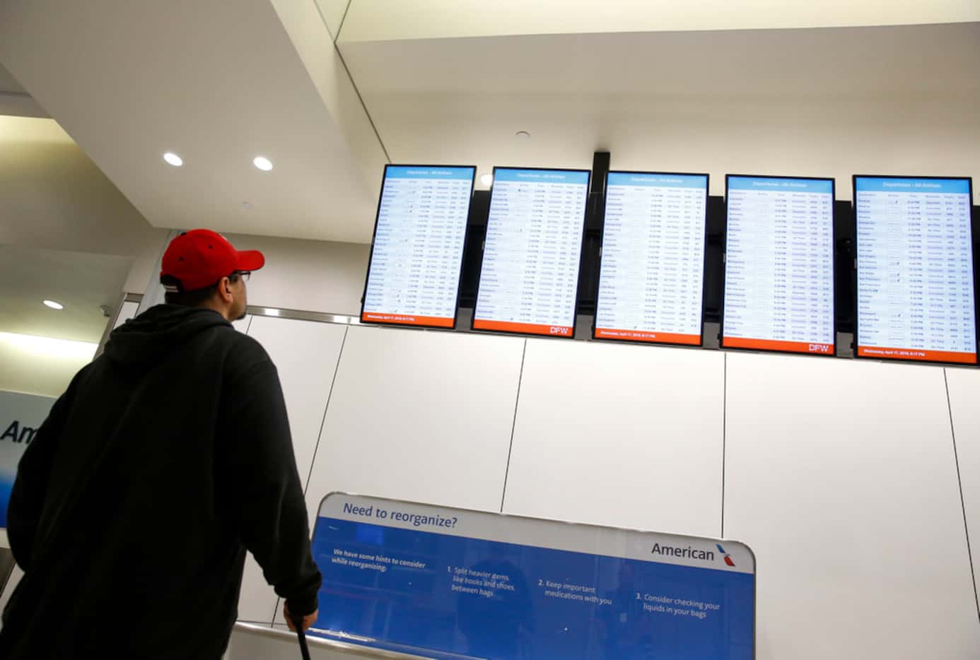 A man looks at the flight boards for an available flight out of DFW Airport on Wednesday...