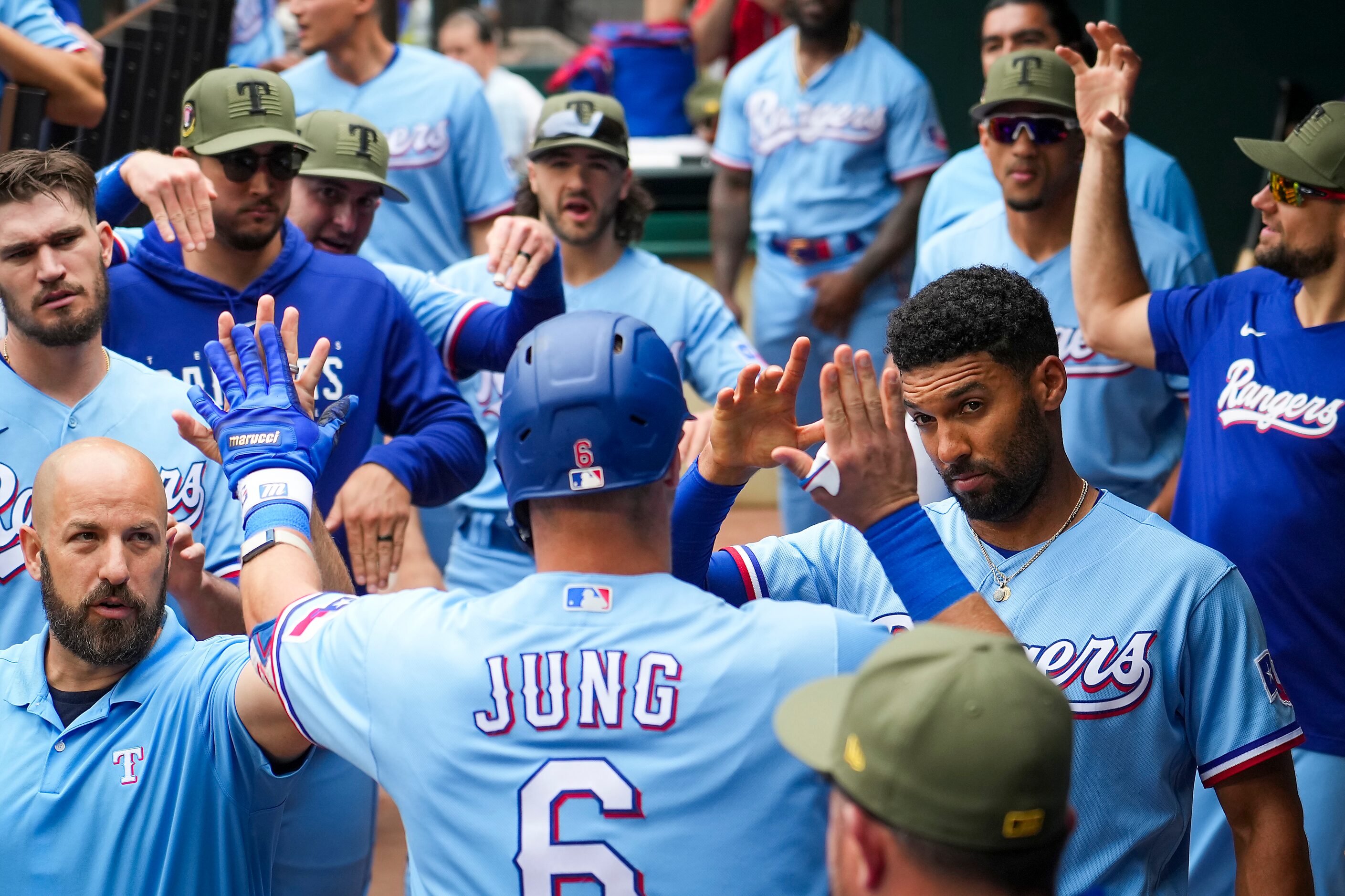 Texas Rangers third baseman Josh Jung gets a hand from second baseman Marcus Semien (facing...