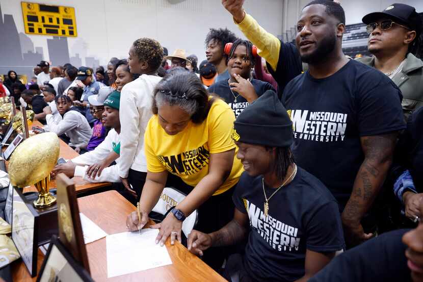 South Oak Cliff football player Daveon Ennis (seated) and his mother LaShema Thibodeaux...
